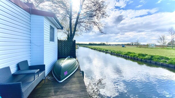 A narrow waterway with a dock and a house on one side.
