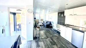A modern kitchen with white cabinets, a black countertop, and a gas stove.