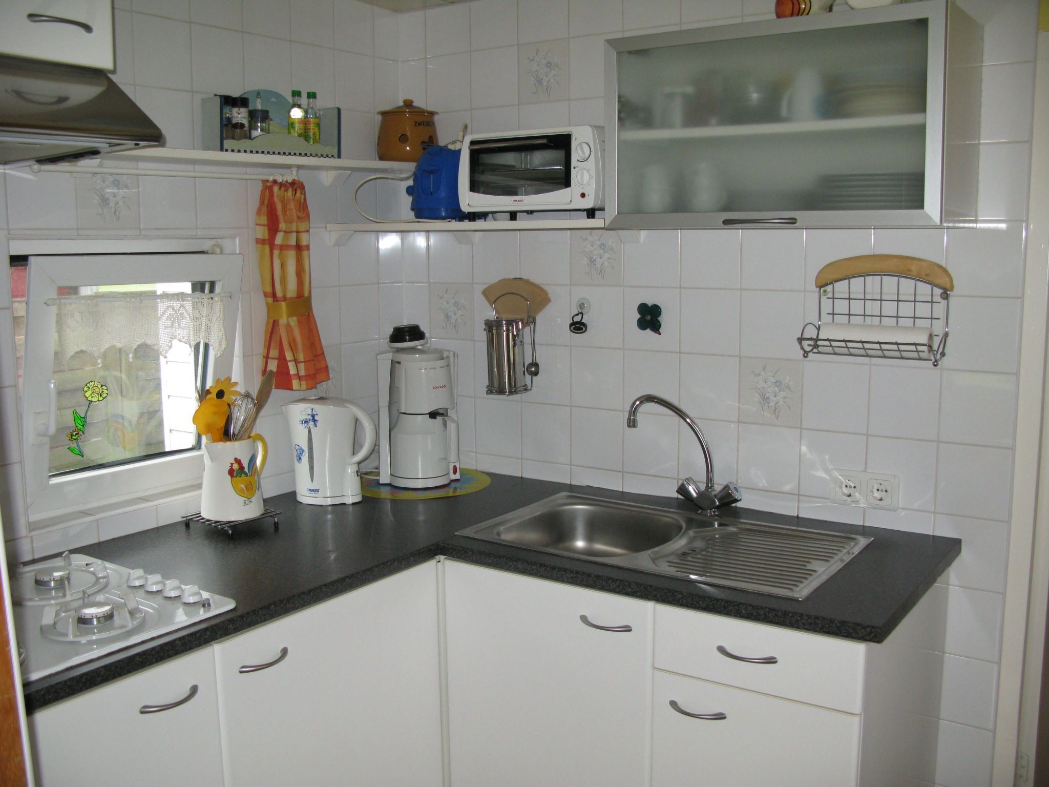Een koelkast, een oven, kookgerei, borden en bestek