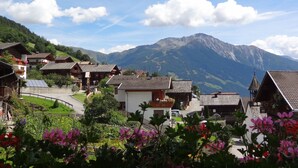 Ein Dorf mit traditionellen Holzhäusern, einer zentralen Straße und einem Berg im Hintergrund.