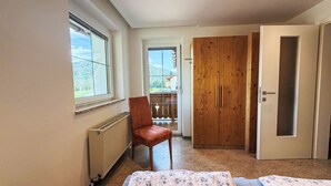 Une chambre à coucher avec un lit, une chaise, une armoire et un radiateur.