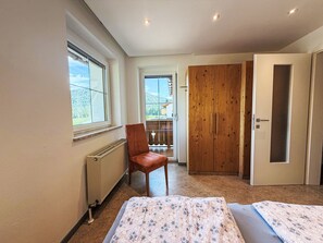 A bedroom with a bed, a chair, a wardrobe, and a radiator. - Haus Schönberg by Interhome (Leutasch)