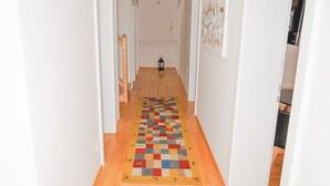 Ein Flur mit Holzdielen und weißen Wänden.