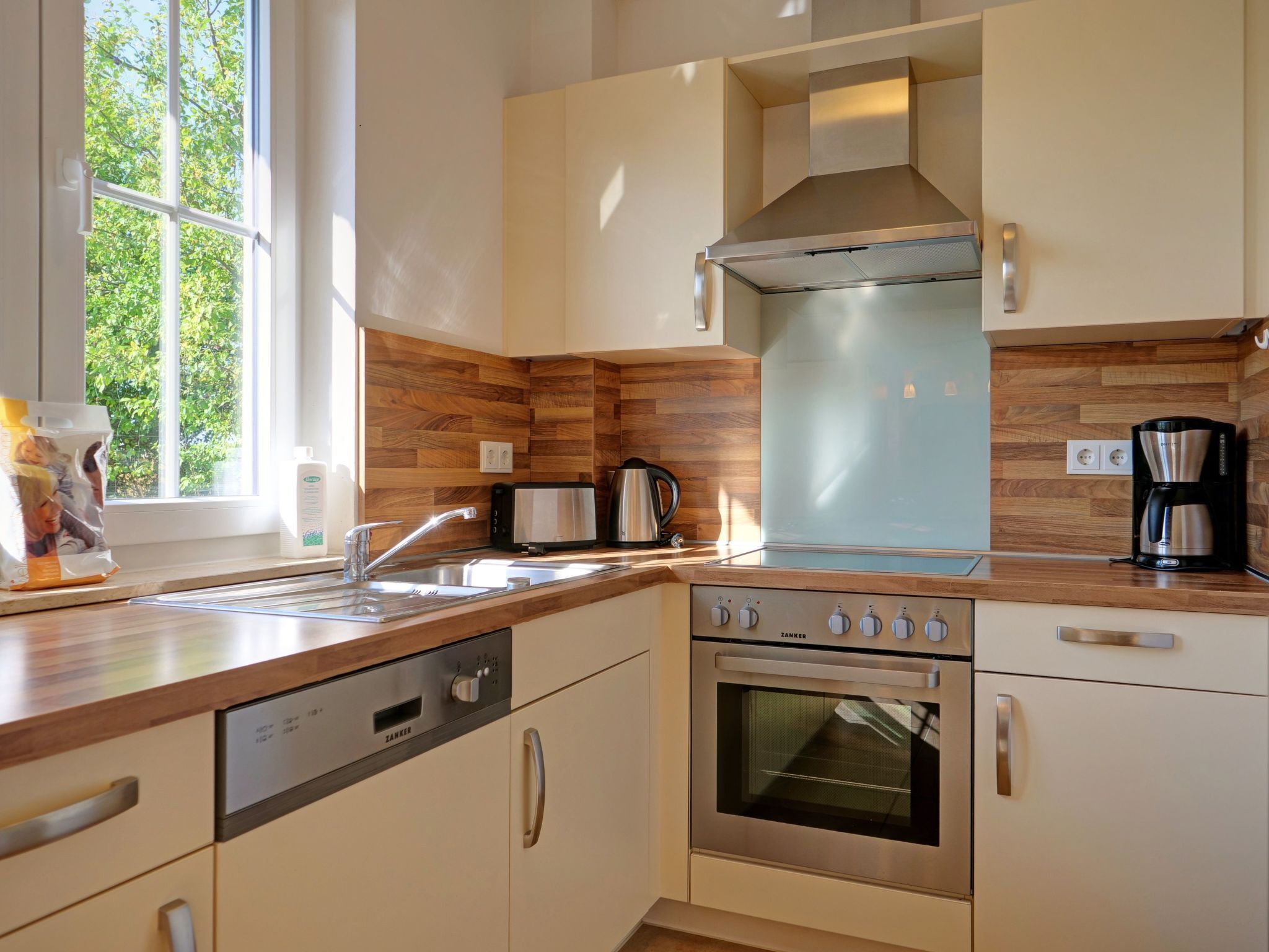 Una cucina moderna con lavastoviglie, forno e macchina del caffè sul piano di lavoro.