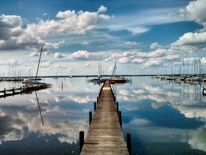 A wooden pier extending into calm waters with boats docked on both sides. - Appartement in Steinhude mit Terrasse und Garten by Interhome (Wunstorf)
