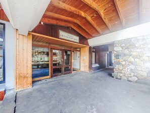 A building entrance with a wooden facade and a stone wall. - Les Olympiades by Interhome (Val Thorens)