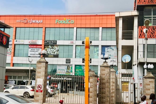 Un edificio con insegna FoodCo, insegna Domino's Pizza e insegna del cinema.