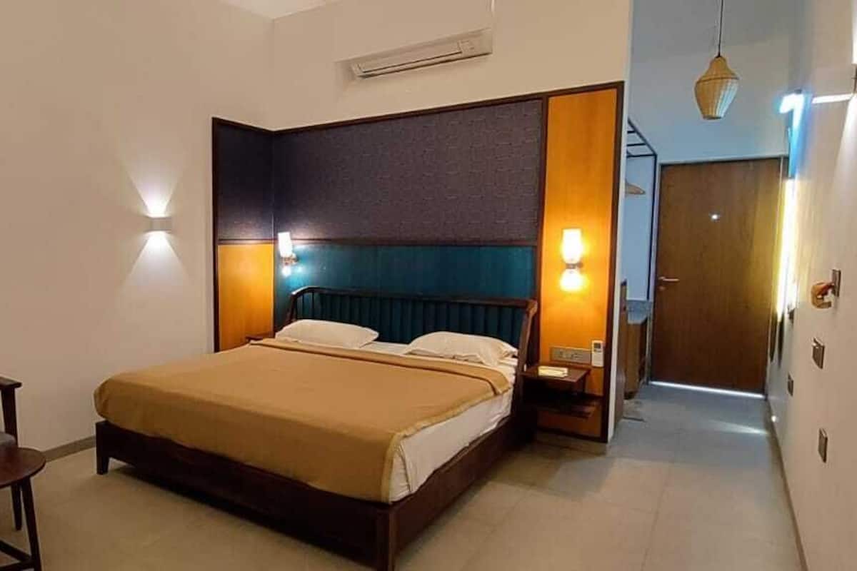 A hotel room with a bed, a chair, and a nightstand.