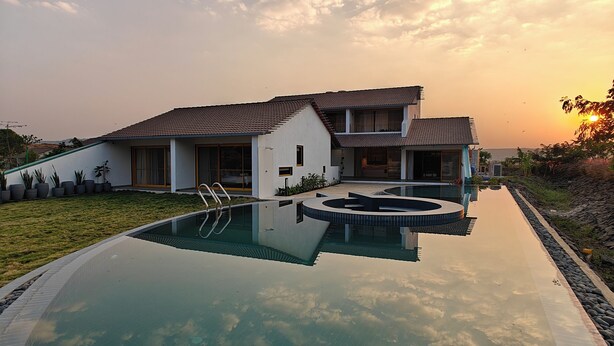 A modern house with a swimming pool, reflecting the sky and clouds. - Touchwood Bliss Resort - Igatpuri (Igatpuri)