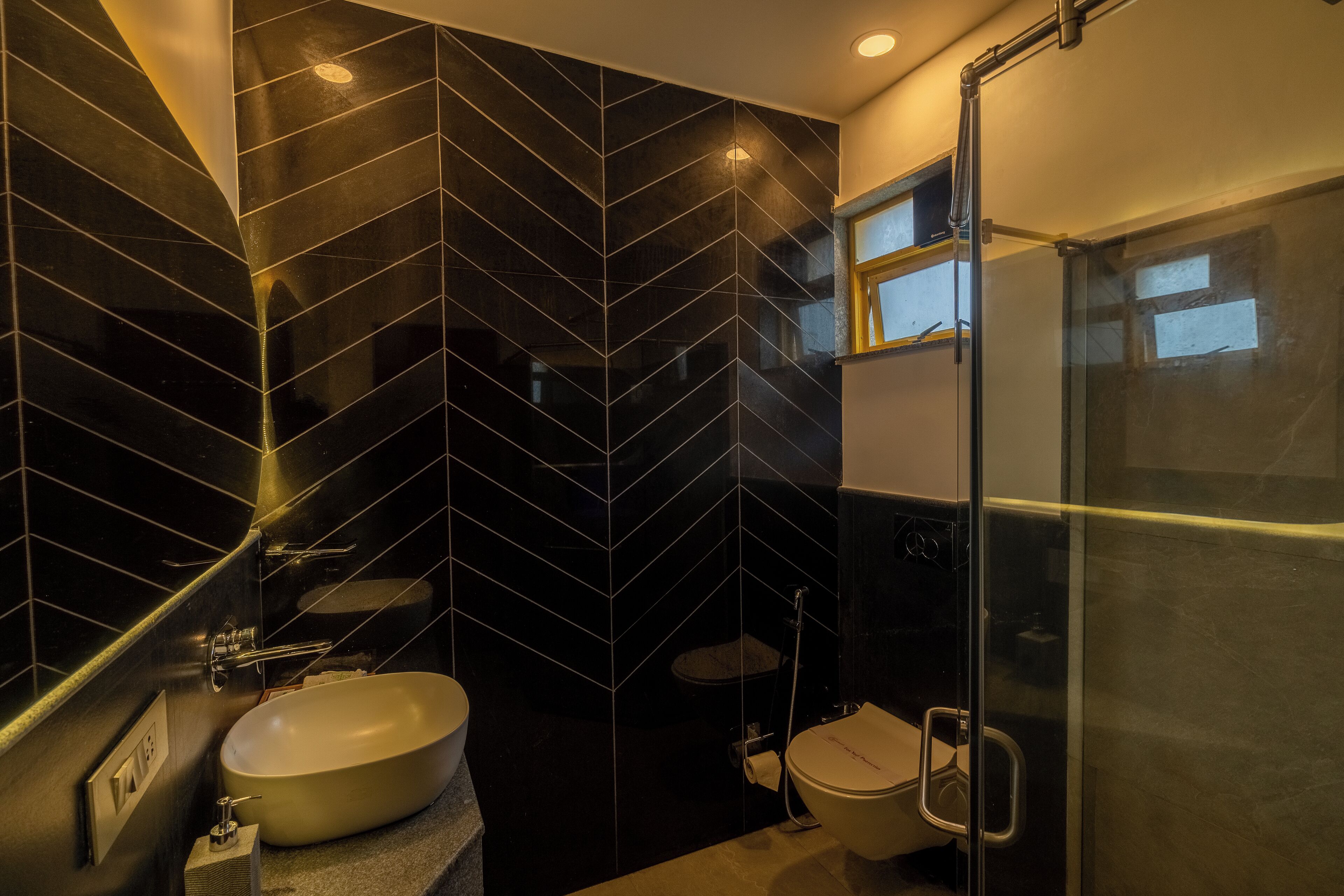Een moderne badkamer met een zwart-wit betegeld design, een wit wastafelmeubel en een douchecabine van glas.
