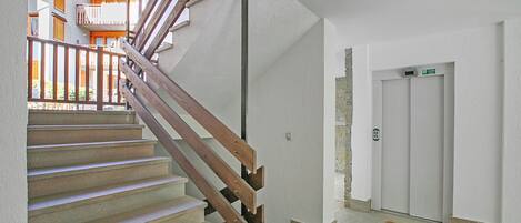 Un escalier avec des rampes en bois menant à l’étage supérieur.