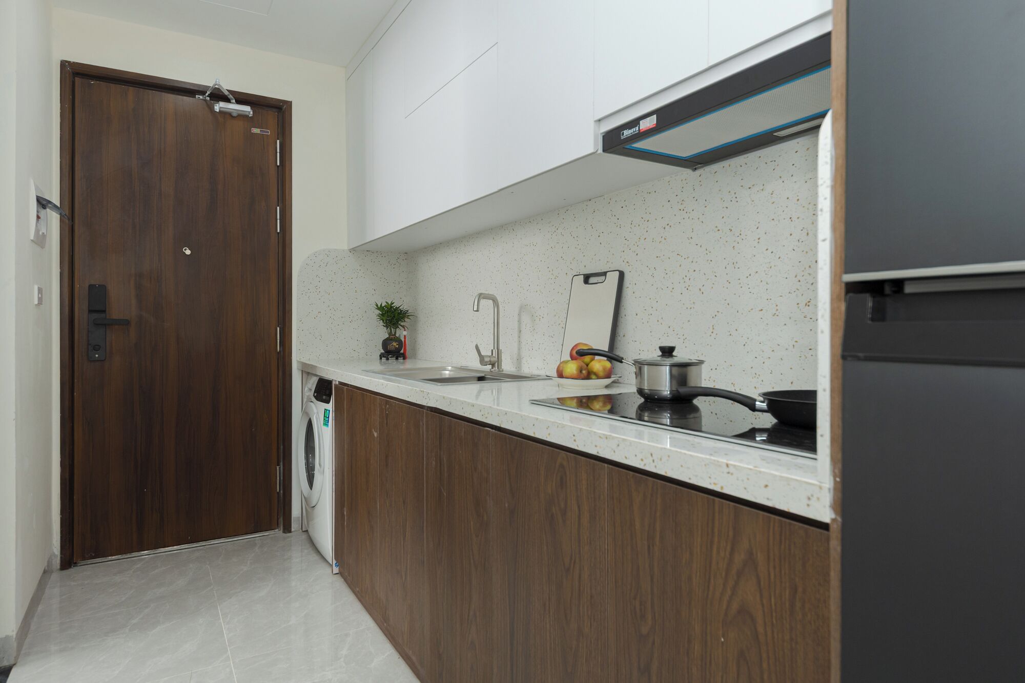 A modern kitchen with wooden cabinets, a stainless steel sink, and a built-in oven.