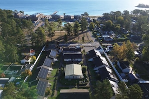 Vista aérea de una zona residencial con casas, un muelle y una playa.
