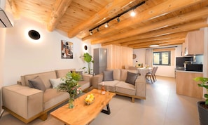 Un saló modern amb sostre de fusta, zona de menjador i cuina amb forn de microones integrat.