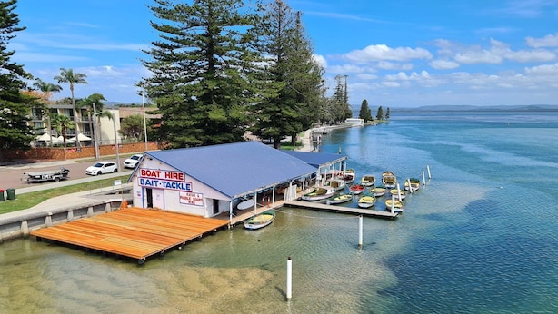 A boat rental facility with a dock and several boats. - Skippers Hideaway - A Peaceful Coastal Escape (The Entrance North)