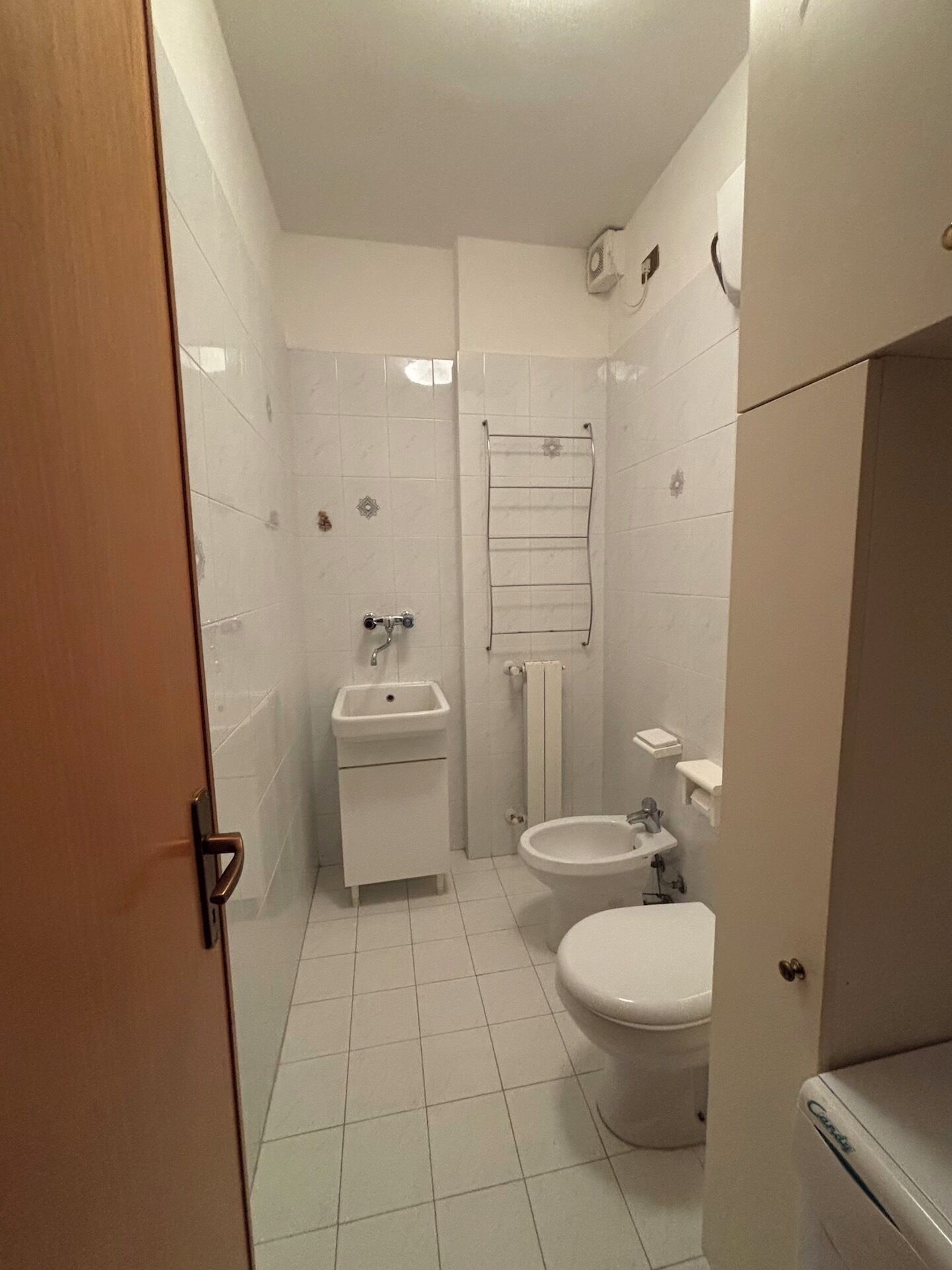 Un baño pequeño y blanco con inodoro, lavabo y bidé.