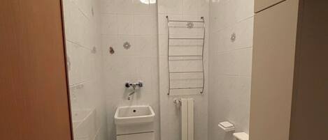 Un baño pequeño y blanco con inodoro, lavabo y bidé.