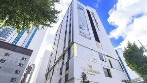 A modern hotel building with a prominent sign for 'Deh Basha Hotel'. - Denbasta Hotel Guseo (Busan)