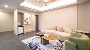 A modern living room with a sofa, a coffee table, and a ceiling fan. - Denbasta Hotel Guseo (Busan)