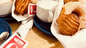 Un tavolo con dolci, una confezione di latte, una bottiglia e una tazza.