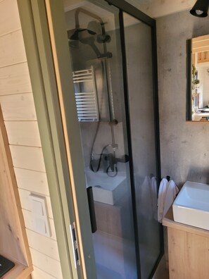 Een douche, handdoeken, zeep, toiletpapier