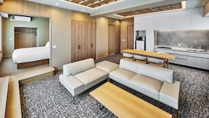 A modern hotel room with a bed, sofa, dining table, kitchenette, and a large window. - MIMARU Osaka Namba Station Annex (Opens on October 1, 2026) (Osaka)