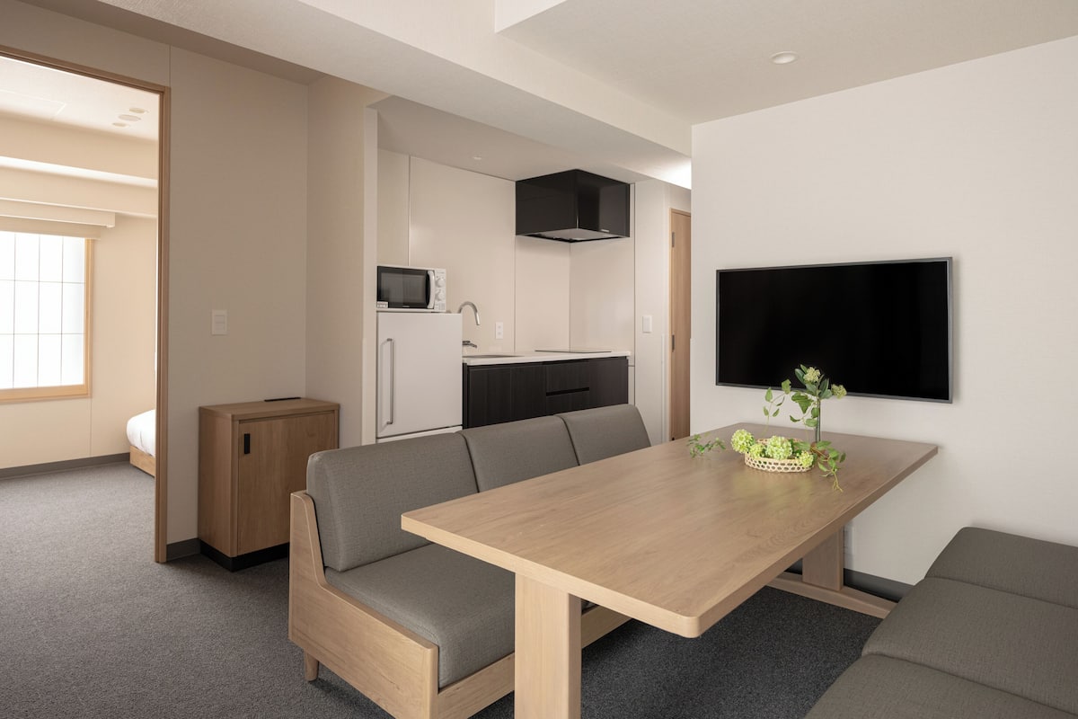 A modern, compact living space with a kitchenette, a dining area, and a seating area.