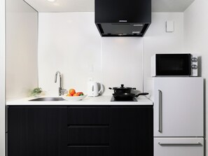 A modern kitchen with a sink, a kettle, a microwave, and a stove. - MIMARU Osaka Namba Station Annex (Opens on October 1, 2026) (Osaka)