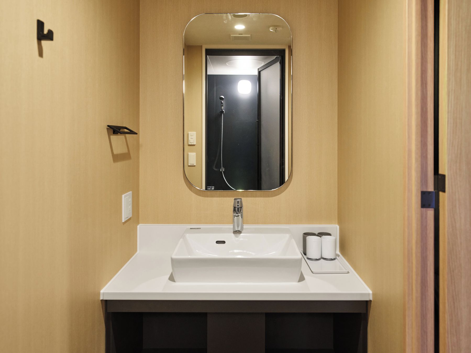 A bathroom with a white sink, a mirror, and a shower.