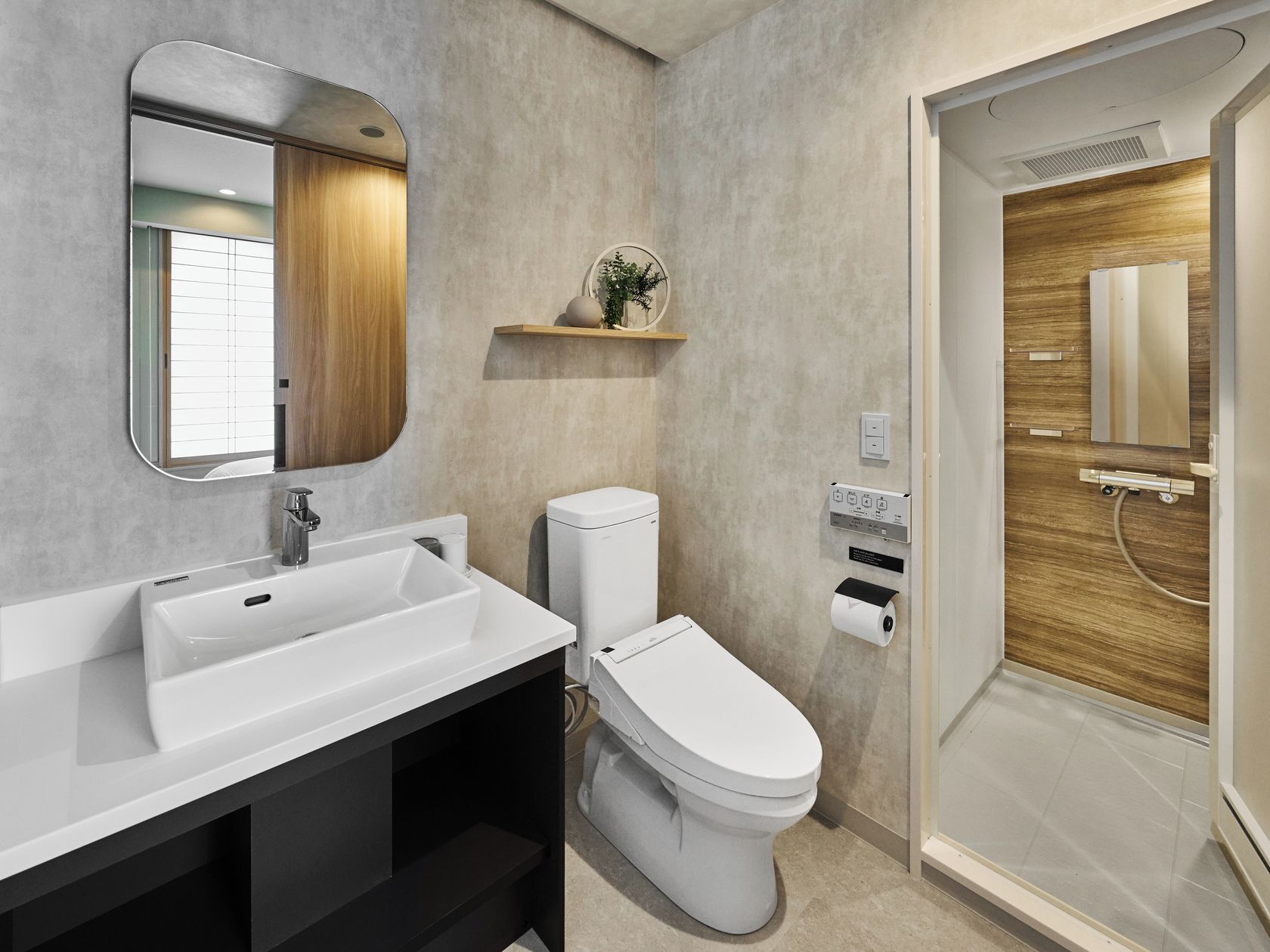 Et moderne badeværelse med en hvid vask, toilet og bruseområde.
