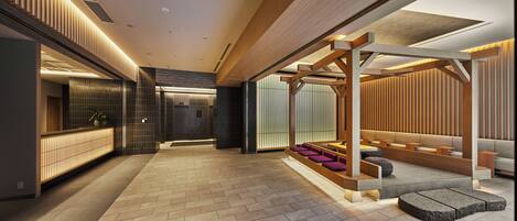 A modern interior with a reception desk, seating area, and a hallway.