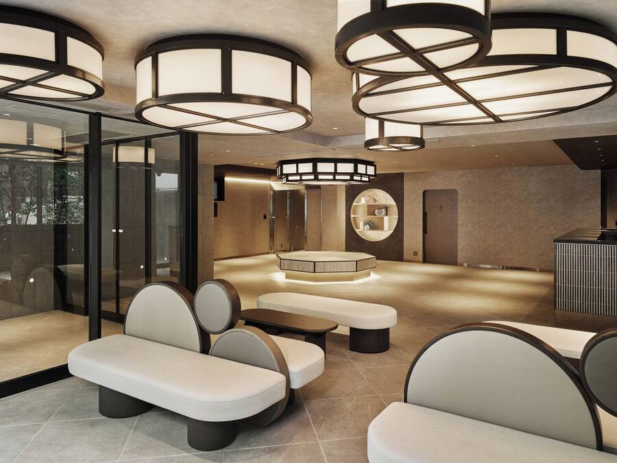 A modern lounge area with seating, a central table, and a circular decorative piece on the wall.