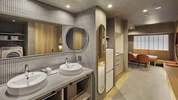 A modern bathroom with dual sinks, a large mirror, and a built-in washing machine.