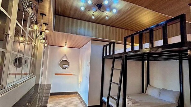 A bunk bed room with a wooden ceiling, a small circular window, and a wall-mounted shelf. - KNB West Villa Inn by SMS Hospitality (Bolinao)