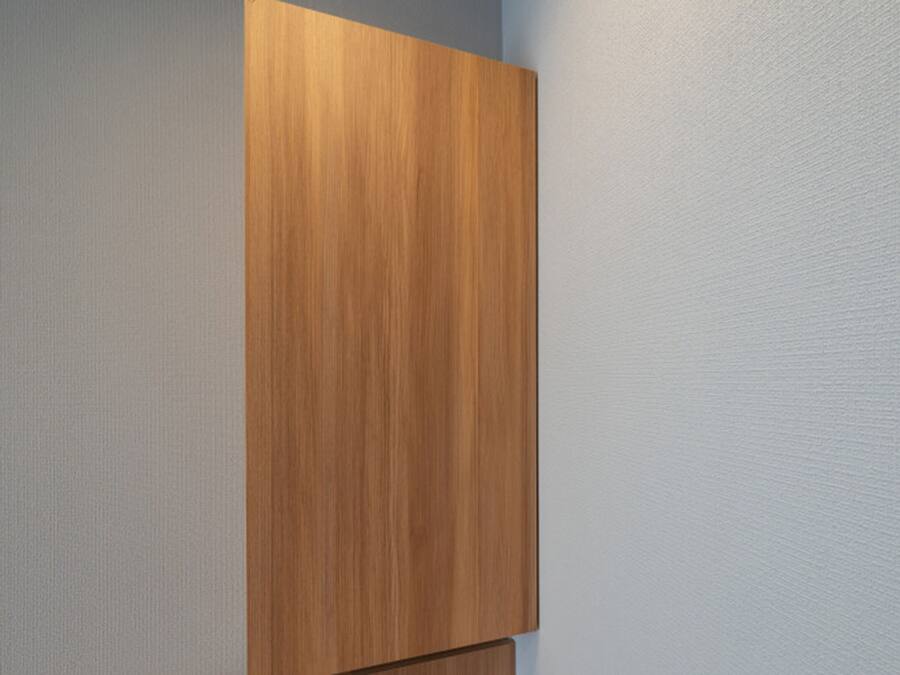 Un armario de madera frente a una pared con textura.