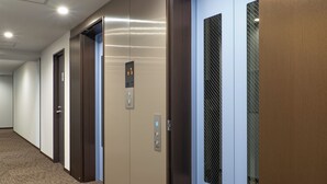 A hallway with three elevator doors, each with a control panel and a keycard slot. - Toyoko Inn Hamamatsu-eki Minami-guchi (Hamamatsu)