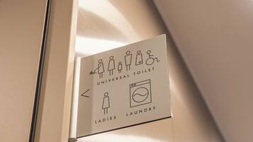 A sign indicating a universal toilet and ladies' laundry facilities.
