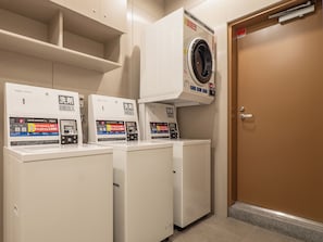 A laundry facility with three white washing machines, each with a digital control panel and a price tag of ¥300. - Toyoko Inn Hamamatsu-eki Minami-guchi (Hamamatsu)