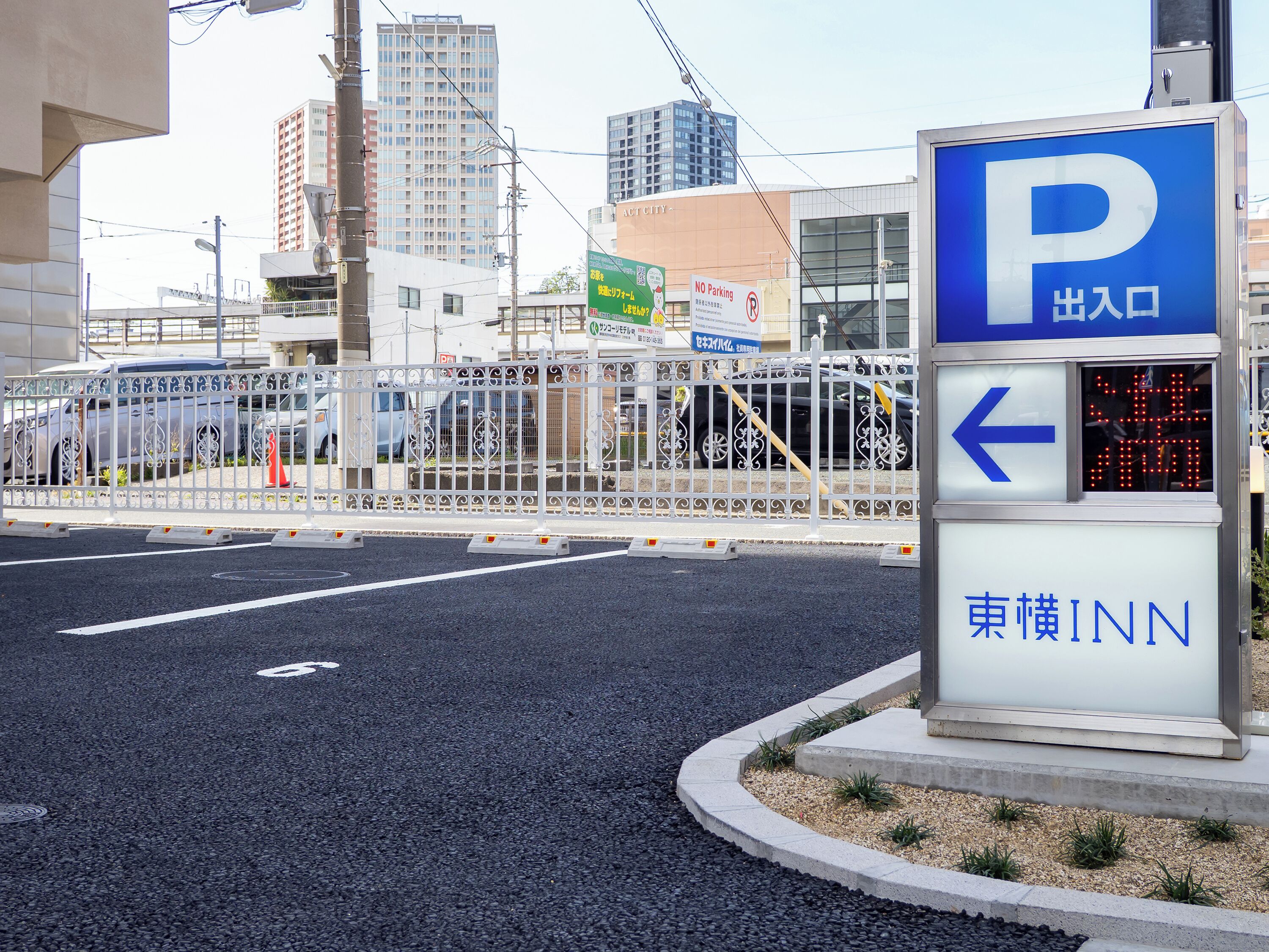 A parking sign with a directional arrow and a hotel name.