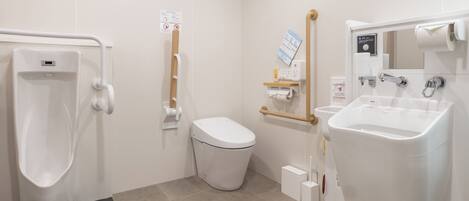 A modern bathroom with a urinal, toilet, and sink.