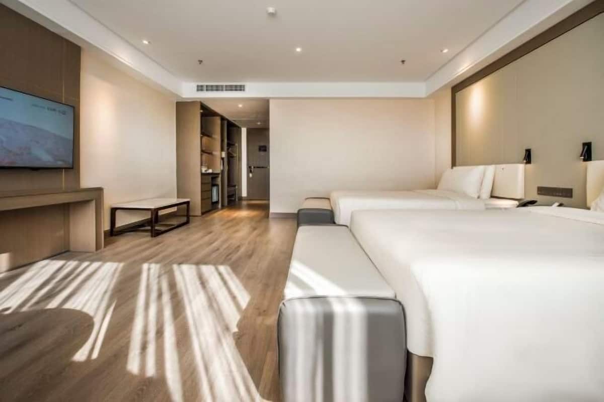 Een moderne hotelkamer met een groot bed, een bureau, een flatscreen televisie en een inloopkast.