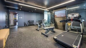 Et moderne fitnesscenter med løbebånd, crosstrainer og vægte.