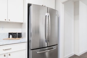 A stainless steel refrigerator in a kitchen with white cabinets and a marble countertop. - Private Pool Oasis: Modern 3BR/2BA. Sleeps 8 (San Diego)