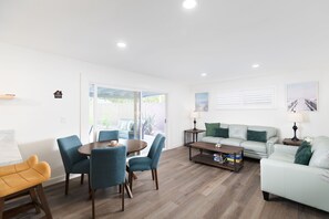 A modern living room with a dining area, a sofa, and a coffee table. - Private Pool Oasis: Modern 3BR/2BA. Sleeps 8 (San Diego)