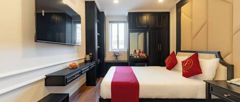 A hotel room with a bed, bedside tables, a TV, a mirror, and a window.