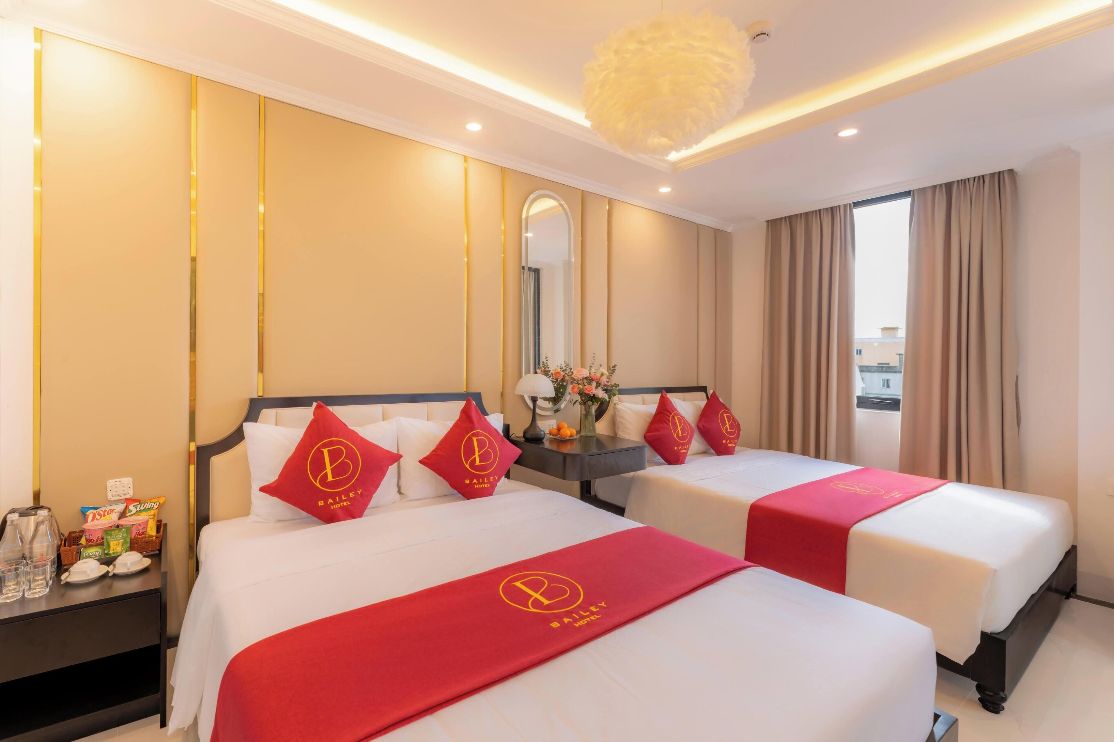 A hotel room with two beds, a nightstand, a mirror, and a window with curtains.