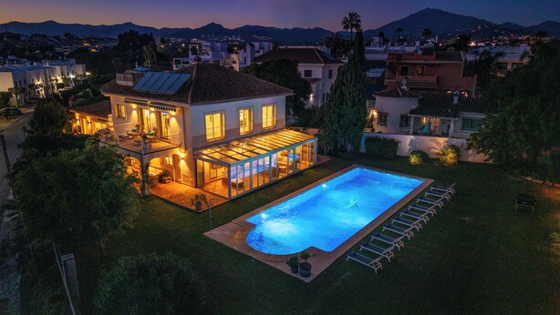Una casa de dues plantes amb piscina, un porxo cobert i vistes al barri proper.