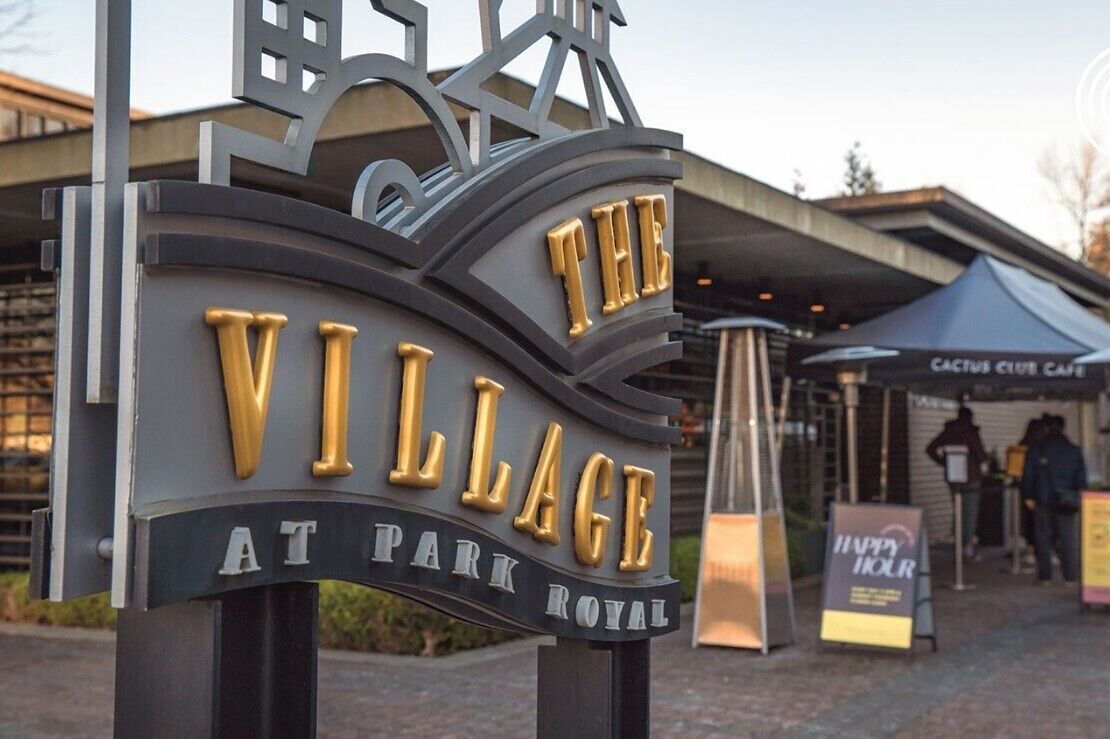 A sign for 'The Village at Park Royal' with a modern design and gold lettering.