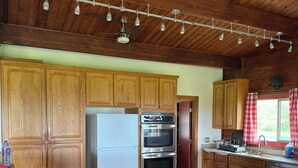 A kitchen with wooden cabinets, a refrigerator, an oven, and a countertop.