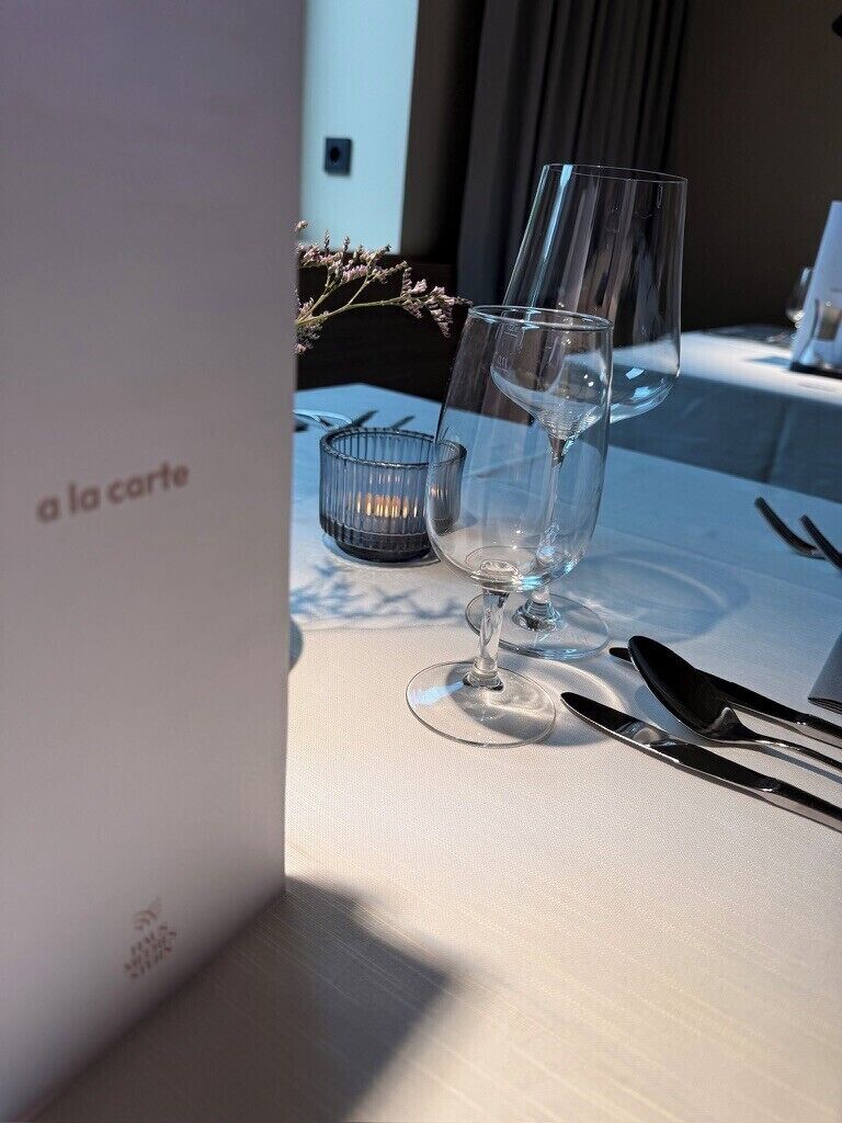 A table set for dining with a menu titled 'a la carte' and a candle holder.